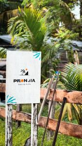 玛哈威Pronoia Casa de Playa的栅栏上的标志,上面有标志