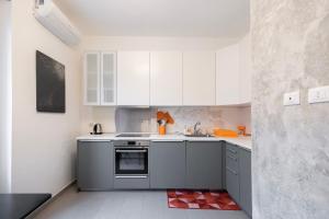 米兰Moderno Appartamento a 2 minuti dalla Metro的厨房配有白色橱柜和水槽