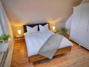 WesselburenLeni的卧室配有一张带两张桌子的大型白色床