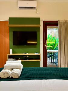 费尔南多 - 迪诺罗尼亚Nari Guest Room的一间卧室配有电视和一张带毛巾的床。