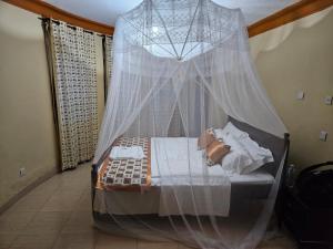 波特尔堡Top of the World Lodges Fort Portal的一间卧室配有一张带蚊帐的床