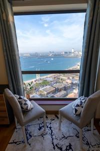 迪拜Nirvana Home的客房设有两把椅子和大窗户