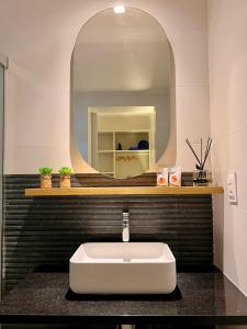 费尔南多 - 迪诺罗尼亚Nari Guest Room的浴室设有白色水槽和镜子