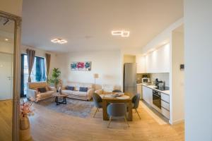 贝尔格莱德SD Luxury Apartment - Belgrade Waterfront的厨房以及带桌椅的起居室。