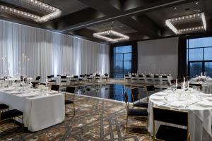 绍斯莱克Delta Hotels by Marriott Dallas Southlake的一个带桌椅的宴会厅,位于带窗户的房间