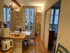 巴黎One-Bedroom Apartment by the Eiffel Tower: your home in the heart of Paris的厨房以及带桌子和一些窗户的用餐室。