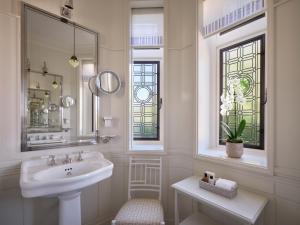 伦敦At Sloane的白色的浴室设有水槽和镜子