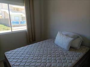 LaranjalApartamentos Beira Mar的一间卧室配有一张带枕头和窗户的床