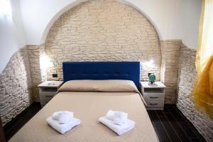 托雷拉皮罗Risa Apulia的一间卧室配有带2条白色毛巾的床