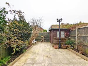 拉斯廷顿Family Home in Rustington, West Sussex的一个带长凳和围栏的花园