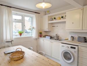 拉斯廷顿Family Home in Rustington, West Sussex的厨房配有桌子和洗衣机。