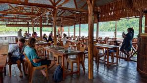 RabiaThe Jeti Mangrove - Ecolodge, Cottage, Restaurant & Kali Biru, Blue River的一群坐在餐厅桌子上的人