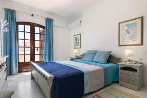 阿尔图拉Roulito's House的一间卧室设有蓝色的床和窗户。