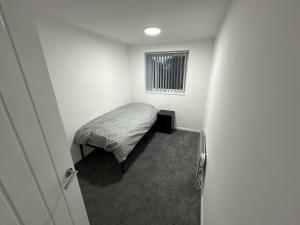 伯明翰Beautiful 2-Bed Apartment in Birmingham的一间小卧室,配有床和窗户