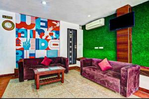 斋浦尔COLLECTION O HOTEL SKY INN的客厅配有两张紫色沙发和一台电视机