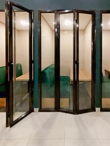 波哥大The Hood 102, Modern and Luxury Apartments的一间设有玻璃门和绿椅的房间