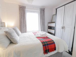 欧文Rosalin Cottage的卧室配有白色的床和窗户。