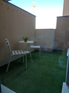 博尔穆霍斯Apartamento Servet, parking gratuito, a 5 minutos de Sevilla的阳台的天井配有桌椅