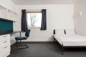 卢顿Wenlock Court的一间卧室配有一张床、一张桌子和一把椅子
