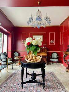 马恩河畔埃索姆玛乔莲城堡酒店的红色的房间,带花瓶的桌子