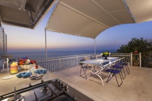 马萨鲁布朗斯AMORE RENTALS - Villa Domus Franca的阳台的天井配有桌椅