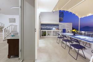 马萨鲁布朗斯AMORE RENTALS - Villa Domus Franca的厨房配有带蓝色椅子的长桌