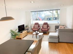 伦敦Bright, spacious, 3-bedroom Emirates apartment with terrace的客厅配有沙发和桌椅