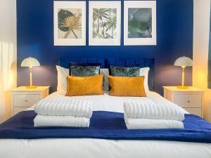 卢顿Phoenix House - 2 Double Bedroom House - Business and Corporate Travellers的蓝色卧室配有一张带枕头的大床