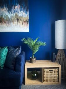卢顿Phoenix House - 2 Double Bedroom House - Business and Corporate Travellers的蓝色的客厅,配有沙发和植物桌子