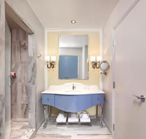夏洛特Grand Bohemian Hotel Charlotte, Autograph Collection的浴室设有蓝色水槽和镜子