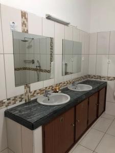 马普托Kutenga Guest House的一间带两个盥洗盆和大镜子的浴室