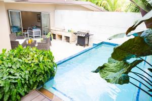Four RoadsGarden Oasis 2 Villa With Private Pool的一个带桌子和一些植物的游泳池