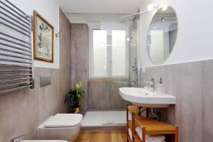 罗马La Flavia Design City Suites Rome的一间带水槽、卫生间和镜子的浴室