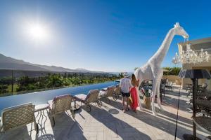 阿德耶Royal River, Luxury Hotel - Adults Only的长颈鹿站在阳台上的 ⁇ 染