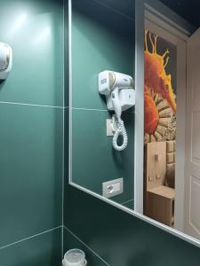 那不勒斯斯可丽齐酒店的一间带镜子和吹风机的浴室