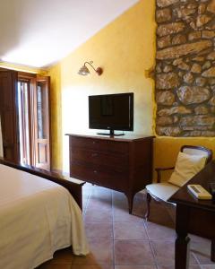 Castelnuovo Parano爱皮科乐伯格罗卡达考奥格酒店的一间卧室配有一张床,梳妆台上配有电视
