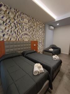 那不勒斯斯可丽齐酒店的一间卧室配有两张带毛巾的床