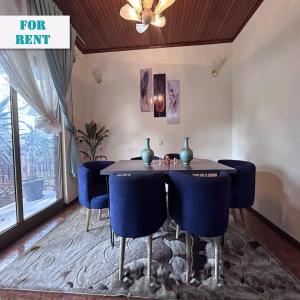 亚的斯亚贝巴A Spacious 4BR 2 Bathroom Villa House @ Bole DT的一间带桌子和蓝色椅子的用餐室