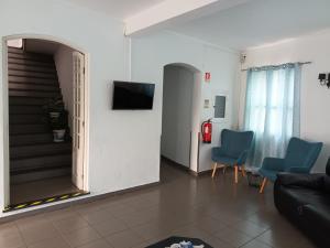 普拉亚达维多利亚布兰科I酒店的一间带楼梯和蓝色椅子的客厅