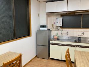 东京Sky Tree INN Ⅱ（晴樹宿Ⅱ）的厨房配有不锈钢冰箱和桌子