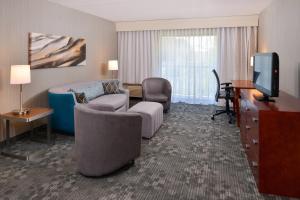 加斯托尼亚夏洛特加斯托尼亚万怡酒店的酒店客房配有一张床、一张书桌和一台电视。