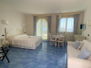 瓦斯托拜亚戴菲斯度假酒店的一间卧室配有两张床、一张桌子和一张沙发