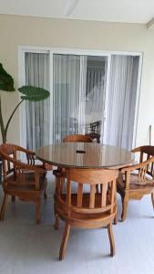 乌鲁瓦图Rumah Menik的一间带木桌和椅子的用餐室