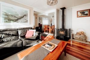 图朗伊Alpine House Tongariro - Turangi Holiday Home的带沙发和燃木炉的客厅