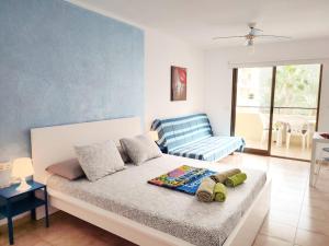 洛斯克里斯蒂亚诺斯Castel Harbour Tenerife的一间卧室配有一张床和一张蓝色的沙发