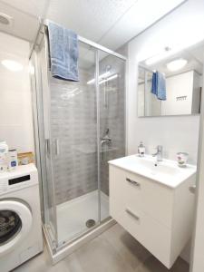 洛斯克里斯蒂亚诺斯Castel Harbour Tenerife的带淋浴、盥洗盆和洗衣机的浴室
