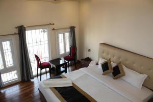 瓦拉纳西Raghunath Palace Home Stay的一间卧室配有一张大床和两张红色椅子