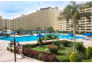 艾因苏赫纳porto sokhna Pyramids Apartment Familis的大型酒店,设有大型游泳池和度假村