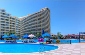 艾因苏赫纳porto sokhna Pyramids Apartment Familis的一座大型酒店,设有游泳池和一座大型建筑