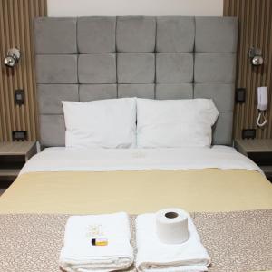 瓦努科Terra Premium Hotel的酒店客房,配有带毛巾的床